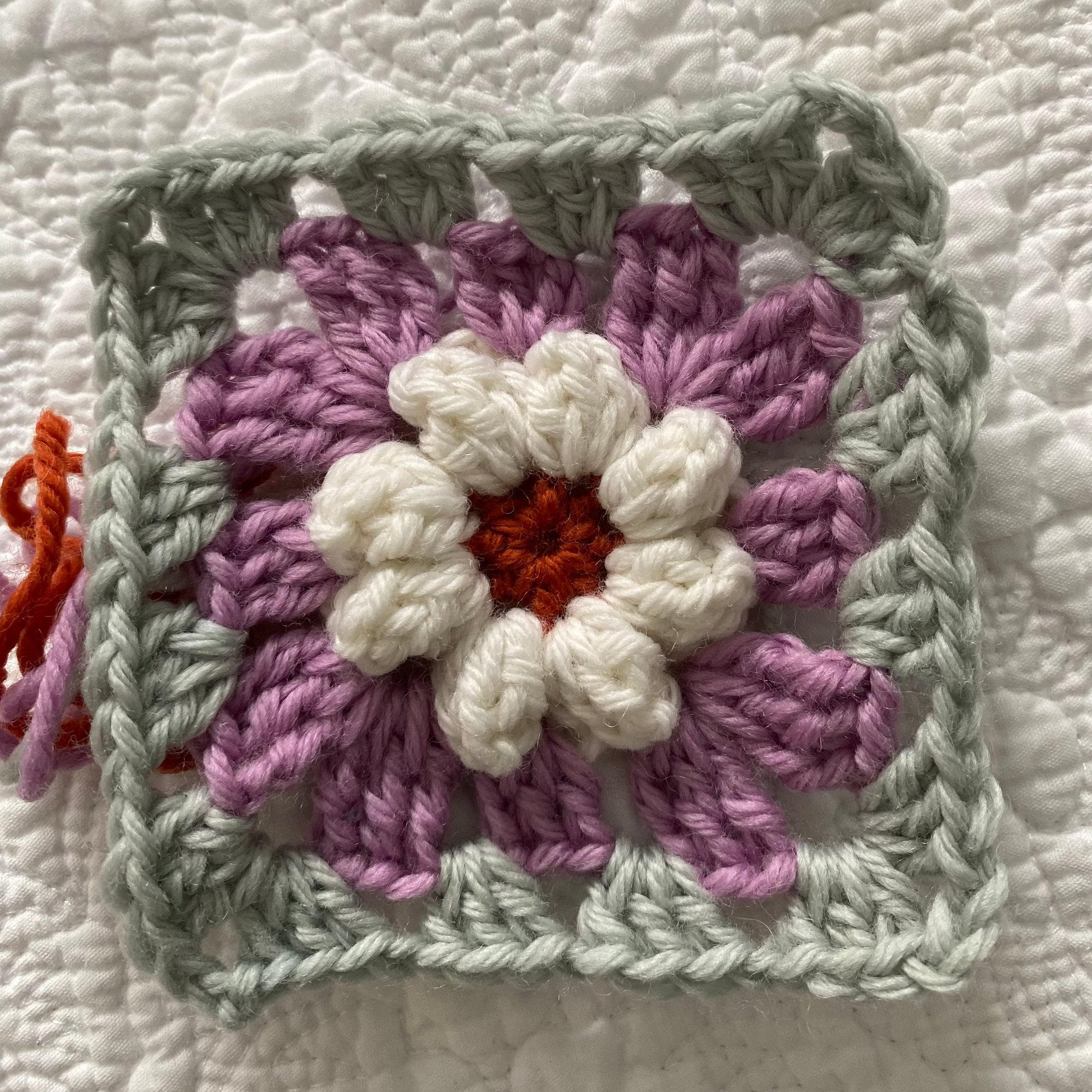 Hands holding crochet hook with even tension on the yarn
