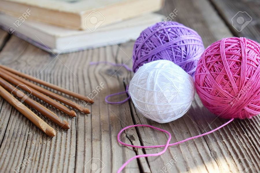 Colorful assortment of yarn balls, crochet hooks, stitch markers, yarn needle, and measuring tape